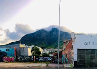 a building with graffiti on it and a mountain in the background