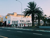 a street scene with palm trees and a building